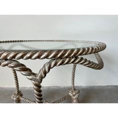 two metal and glass tables with twisted rope around them, one on each side the other