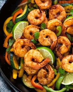 shrimp and peppers in a skillet with lime wedges