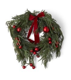 a christmas wreath with red ornaments hanging from it's sides and a bow on top