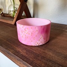 a pink bowl sitting on top of a wooden table