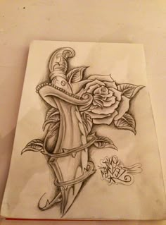 a drawing of a rose and dagger on paper