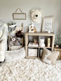 a white teddy bear sitting on top of a bed next to a wooden shelf filled with stuffed animals