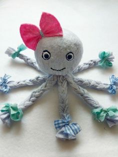 an octopus doll with a pink bow on it's head and two blue bows around its neck