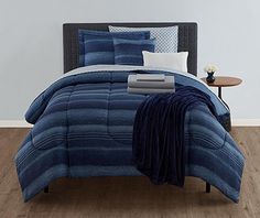 a bed with blue comforters and pillows