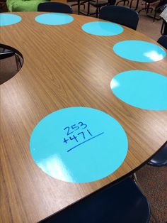 a wooden table with blue circles on it in an office setting, showing the number twenty seven