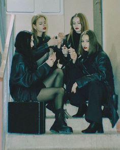 three women sitting on the steps with their hands together