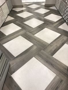 a bathroom with white and gray tiles on the floor