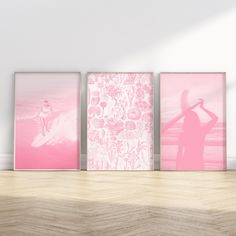 three pink posters are on the wall next to a wooden floor and a white wall