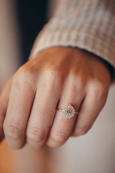 a woman's hand with a diamond ring on her finger, showing the middle finger