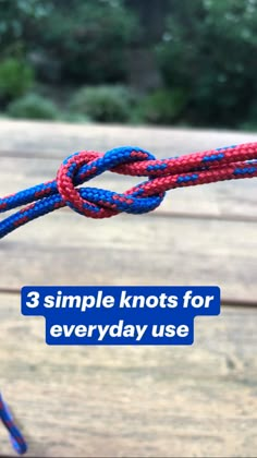 a red, white and blue rope on top of a wooden table with trees in the background