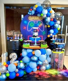 a birthday party with balloons and games on the table, including a video game controller