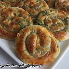 a white plate topped with rolls covered in cheese and spinach