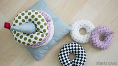 three donuts are sitting on the floor next to a cushion and pillow, one is made out of fabric