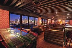 the interior of a restaurant with wooden tables and bar stools in front of large windows