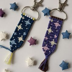 two keychains with stars on them and one has a tassel hanging from it