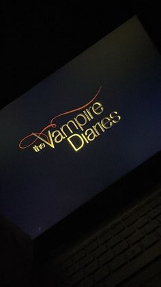 the vampire dance logo is lit up on a laptop computer screen at night with it's keyboard illuminated