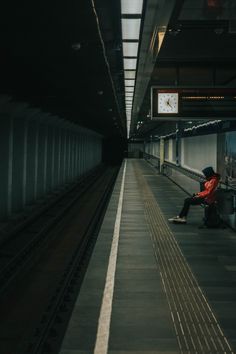 a person sitting on a bench in a train station