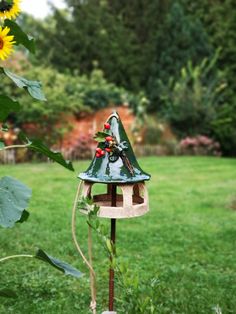 a bird house with sunflowers in the background