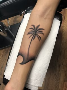 a person with a palm tree tattoo on their arm