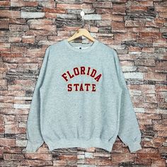 Vintage 90s Distressed Florida State by Champion Sweatshirt Florida Crewneck Florida Pullover Embroidery Logo Gray Color Men's M Label : Champion Size : M (refer the measurement) Made in Mexico Materials from 50% Cotton 50% Polyester Used Item With Condition 6/10 Refer Picture. Stain and No Holes. Lay Down Flat Measurement : - Width (armpit to armpit) and: 22 Inches - Length (shoulder to end of garment): 26 Inches We are selling used clothing with good condition. DO NOT EXPECT the item is like n Casual Embroidered Tops For College, College Crew Neck Sweater With Embroidered Graphics, Casual College Sweatshirt With Embroidered Text, Vintage College Sweatshirt With Embroidered Text, Vintage Letter Embroidery Sweatshirt For Streetwear, Casual College Sweater With Letter Embroidery, Casual Crew Neck Sweater With Embroidered Text, College Crew Neck Sweater With Letter Embroidery, Retro Embroidered Crew Neck Sweater