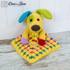 a crocheted dog sitting on top of a blanket