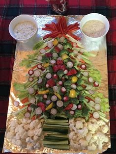 a christmas tree made out of veggies and dips on a platter