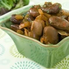 a green bowl filled with mushrooms and onions