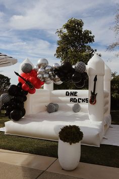 an inflatable stage set up for a party with balloons and black and white decorations