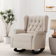 a living room with a rocking chair and potted plant