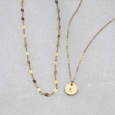 Two of our best selling necklaces in one set! Choose gold filled or sterling silver. Perfect for your everyday tee shirts, makes a wonderful gift too. -Set of two necklaces -Top Layer is a chain style in your choice -Bottom Layer Disc Necklace -Petite disc measures 10mm -Choose 14kt Gold-Filled or Sterling Silver -A high quality delicate link chain. -Polished to a light satin finish. CUSTOM HAND STAMPING -Hand stamped in classic block font with an initial. -Your choice of text up to 3 letters on