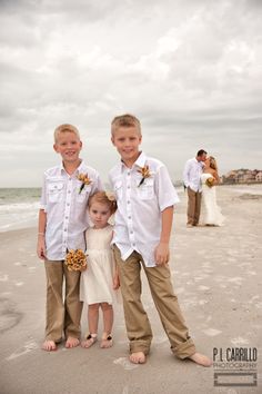 two young boys standing next to each other on the beach