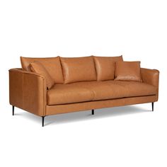 a tan leather couch sitting on top of a white floor