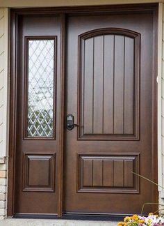 the front door to a house with flowers on the side