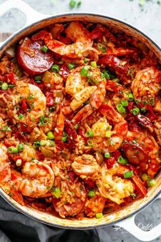 a pot filled with shrimp and vegetables on top of a table