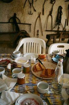 a table topped with lots of food next to cups and saucers on top of a table