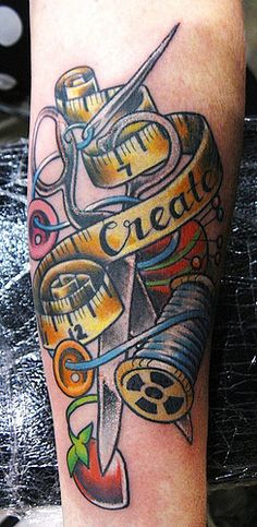 a tattoo on the leg of a person with scissors and sewing needles in it that says create