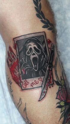 a man's leg with a tattoo on it and a knife in the middle