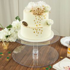 a white wedding cake with gold decorations and flowers on the top is surrounded by confetti