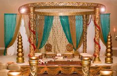 a decorated bed with gold and blue drapes