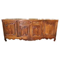 an old fashioned wooden sideboard with carvings on the doors and drawers, against a white background