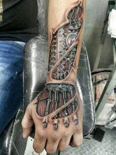 a man with a tattoo on his arm and hand is holding an object in the shape of a skeleton