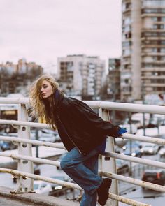 a woman leaning on a railing in the city