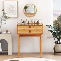 a small wooden table sitting in front of a mirror next to a potted plant