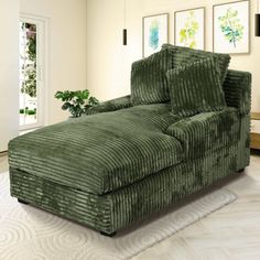 a large green couch sitting in a living room on top of a white carpeted floor