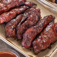 barbecue ribs on a tray with dipping sauce