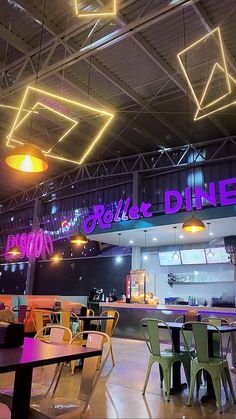 the inside of a restaurant with tables, chairs and neon lights hanging from the ceiling