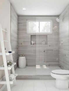 a white toilet sitting in a bathroom next to a window and a shelf with vases on it