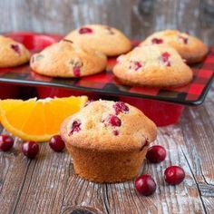 muffins with cranberries and orange slices on a red tray next to it