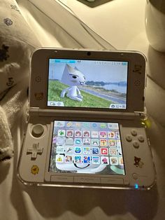 a nintendo wii game system sitting on top of a bed next to a stuffed animal