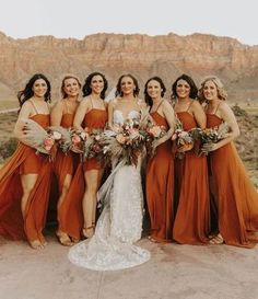 a group of women standing next to each other in front of a mountain range with flowers